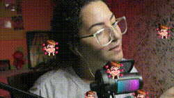 a woman wearing glasses is taking a picture of herself with a microphone .