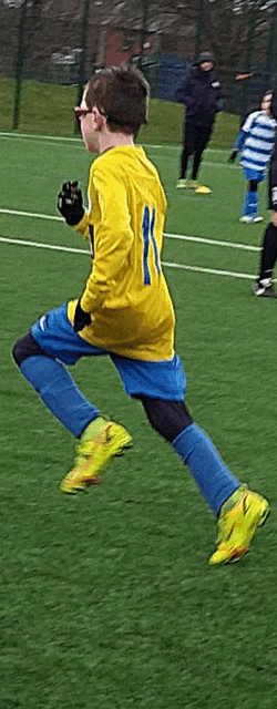 a boy in a yellow shirt with the number 11 on it