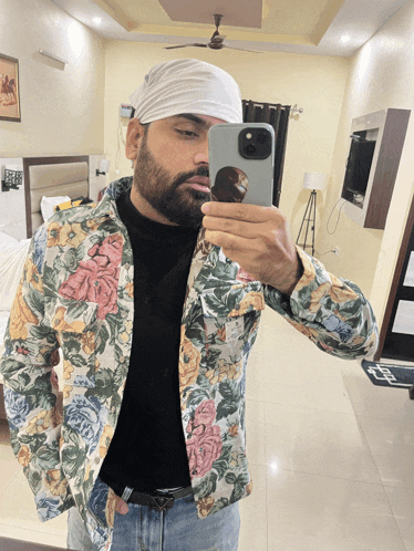 a man in a floral jacket takes a selfie with his phone