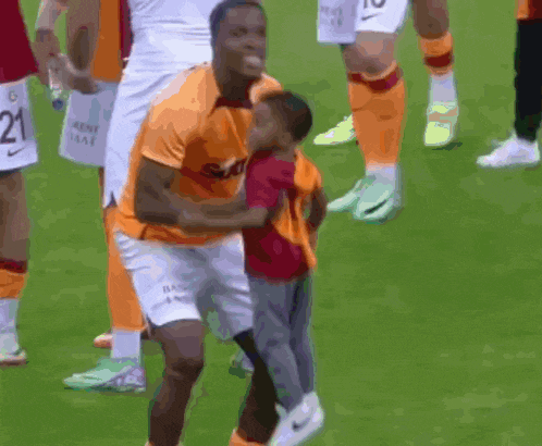 a soccer player holding a child with the number 10 on his shorts