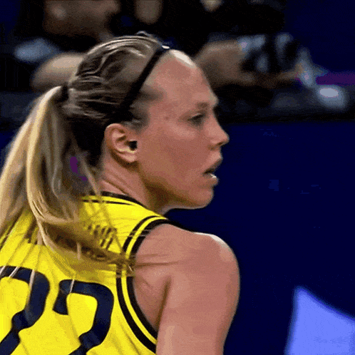 a woman in a yellow jersey with the number 22 on the back