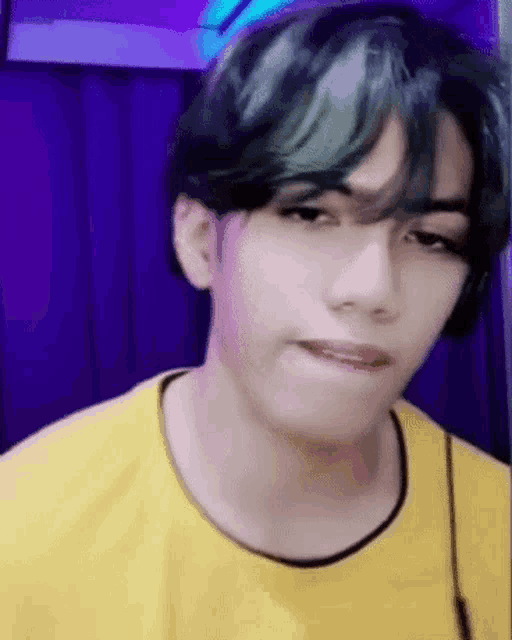 a close up of a young man wearing a yellow shirt and headphones .