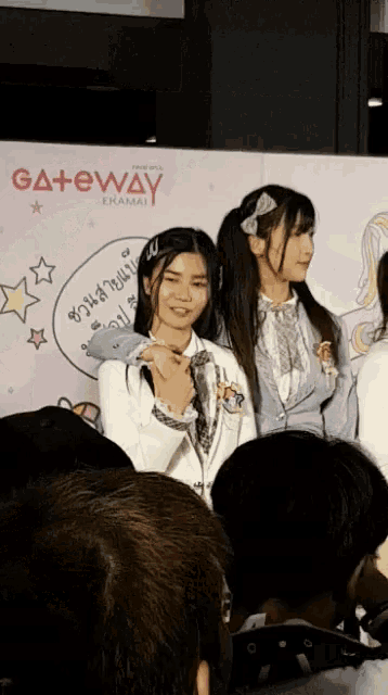 two girls standing in front of a gateway sign