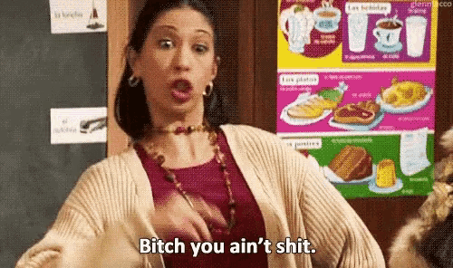 a woman is standing in front of a poster that says bitch you ain 't shit