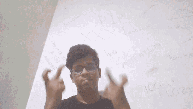 a young man giving the middle finger in front of a wall that says rip xxx