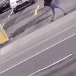 a person is walking down a street with an umbrella in their hand .