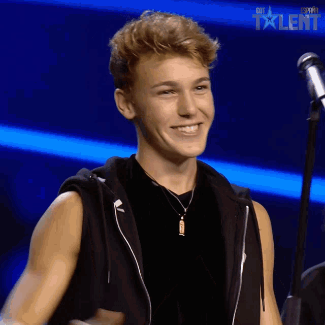 a young man is smiling in front of a microphone and the word talent is on the bottom