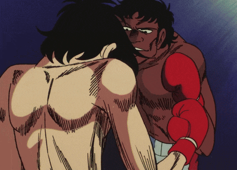 a man in red boxing gloves stands next to a shirtless man