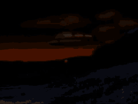 a flying object is flying in the night sky over a field .
