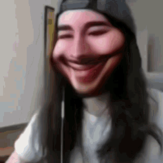 a woman with long hair is wearing a hat and smiling with her eyes closed .