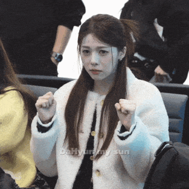 a girl in a white coat with the name dahyun on the bottom right