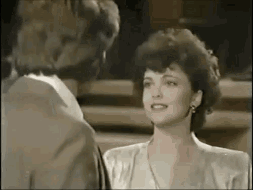 a man and a woman are standing next to each other in a room .