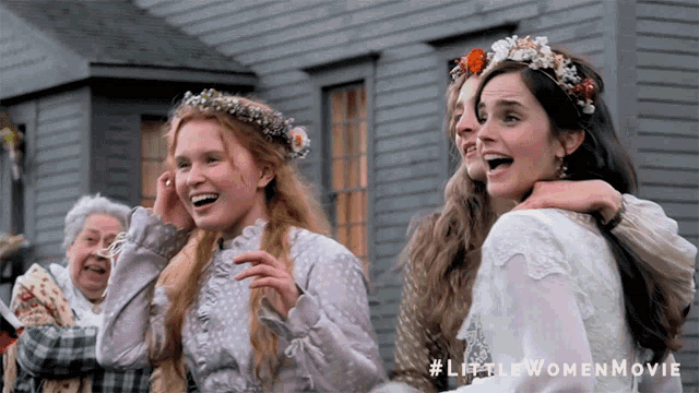 a little women movie poster shows three women laughing in front of a building