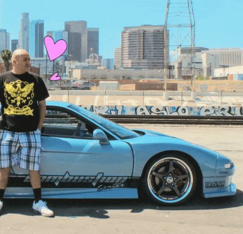 a man standing next to a car that has the word rays on the side