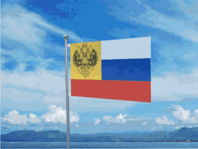 a red white and blue flag with a yellow emblem on it
