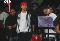 a man wearing a red hat with the letter p on it stands in front of a laptop