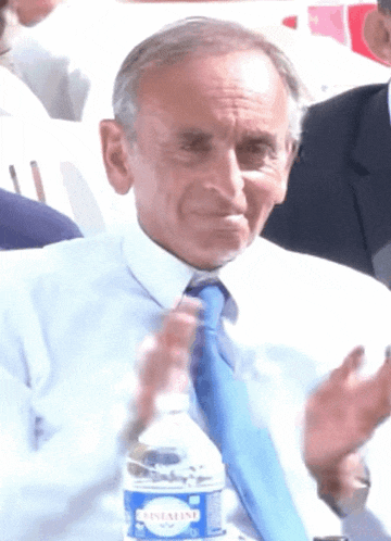 a man in a white shirt and blue tie holds a bottle of crystalline water