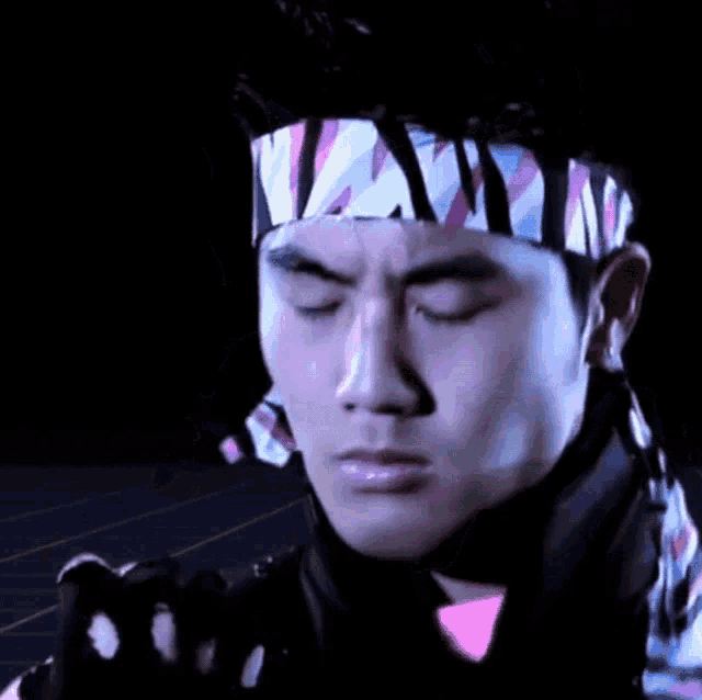 a close up of a man wearing a headband with the letters nv on it