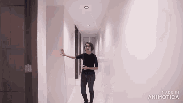 a woman in a black shirt is walking down a long hallway made in animatica