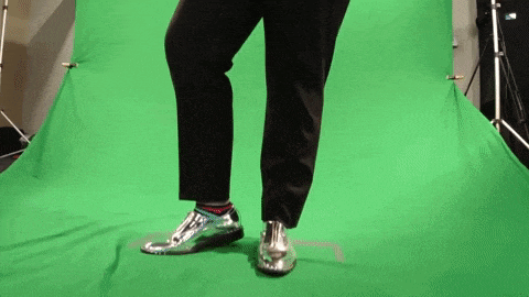 a person is dancing on a green screen wearing silver shoes