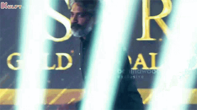 a man is standing in front of a sign that says gold on it .