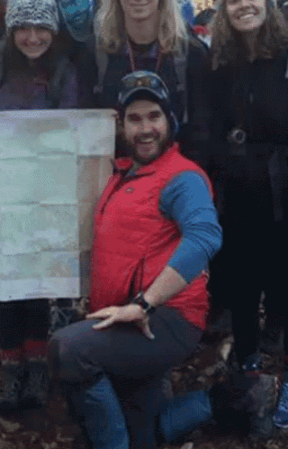 a man in a red vest is posing for a picture