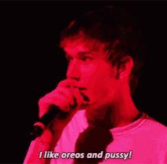 a man singing into a microphone with the words " i like oreos and pussy " next to him