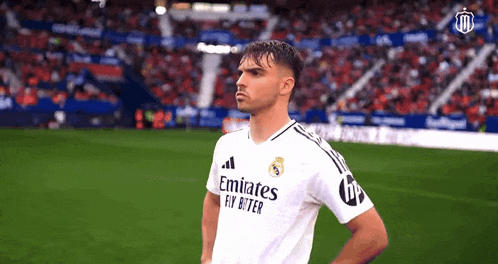 a soccer player wearing a white emirates fly better shirt