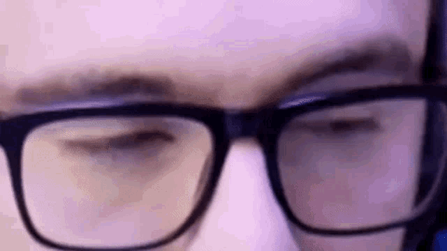 a man wearing glasses and a headset is looking at the camera .