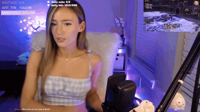a woman is sitting in front of a microphone with a screen behind her that says daily subs 5/5