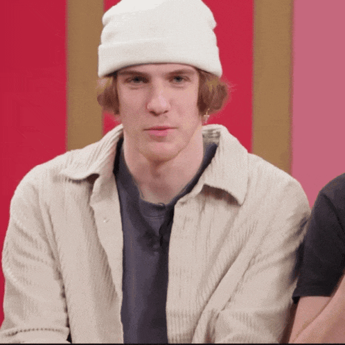 a young man wearing a white beanie and a white shirt