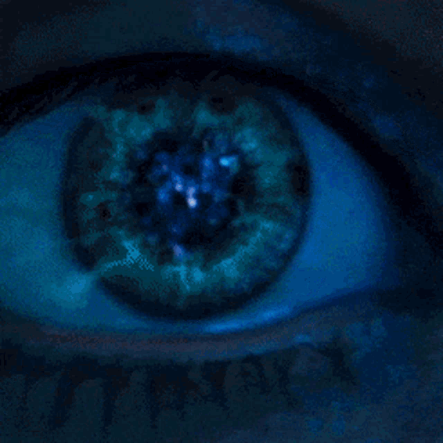 a close up of a woman 's eye with a blue light shining through it