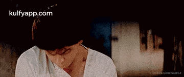 a man in a white shirt is sitting in front of a woman in a red shirt .