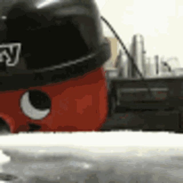 a red and black vacuum cleaner is sitting on top of a counter .