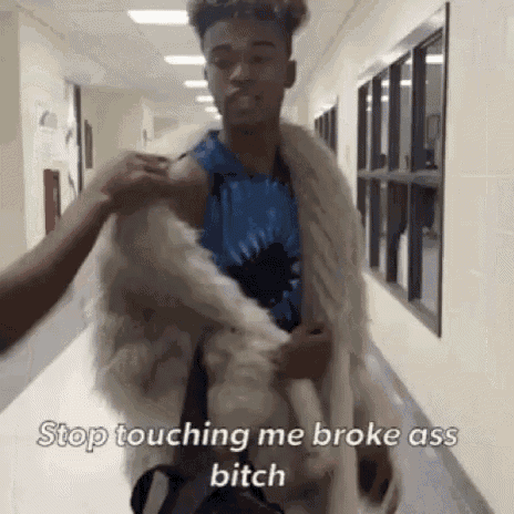 a man wearing a fur coat is standing in a hallway and says `` stop touching me broke ass bitch ''