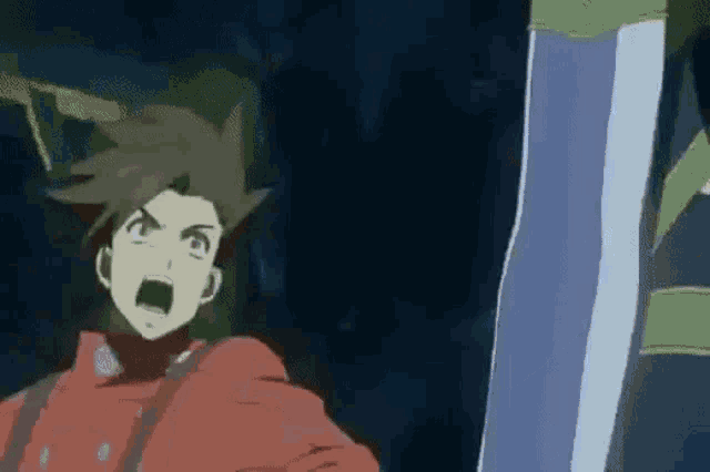 a man in a red jacket is screaming in a dark room .