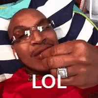 a man wearing sunglasses and a ring is making a funny face and says lol .