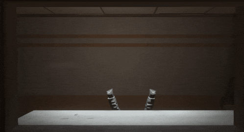 a dark room with a table and chairs and a light shining on it