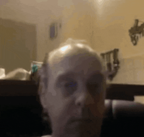 a close up of a man 's face in front of a mirror in a bathroom