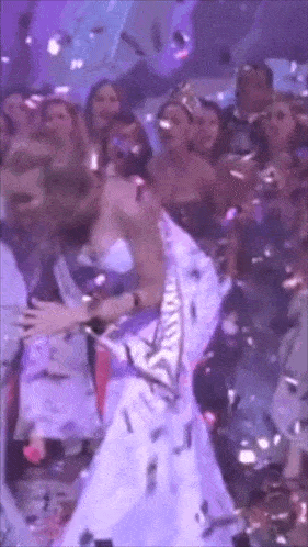 a woman in a white dress is dancing in a crowd of people
