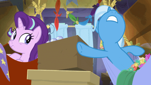 a blue pony is standing next to a purple pony in a box