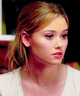 a close up of a woman wearing a white shirt and a necklace