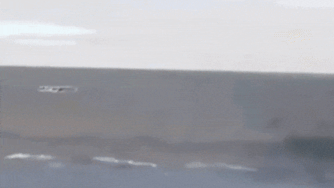 a close up of a jet flying over a body of water .