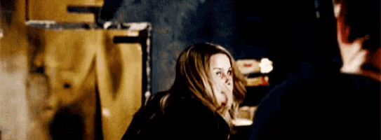 a man and a woman are sitting at a table talking to each other .