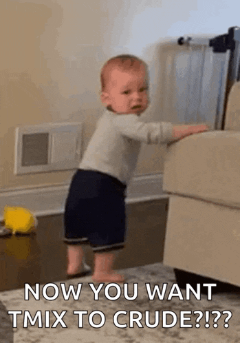 a baby is standing next to a couch in a living room and crying .