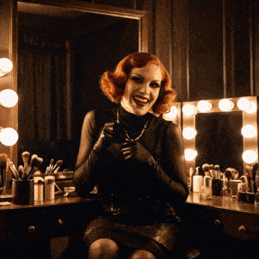 a woman sitting in front of a mirror with makeup brushes on it