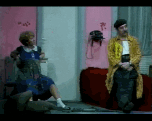 a man in a yellow coat sits in front of a woman in a blue dress