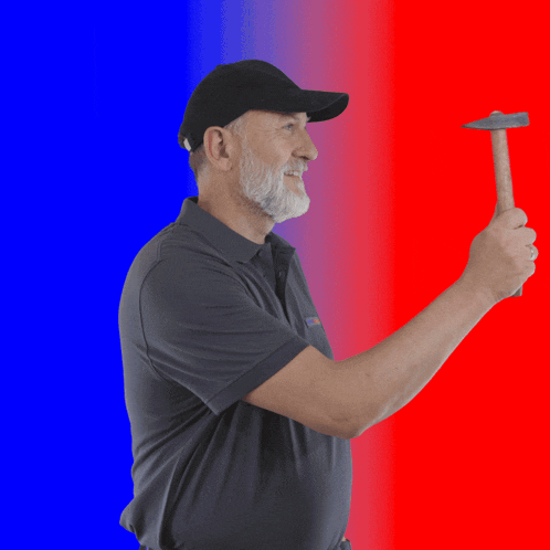a man wearing a black hat is holding a hammer in his right hand