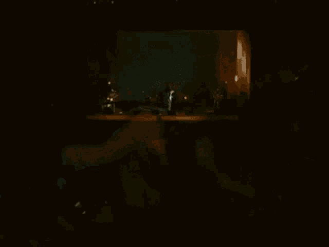 a man in a leather jacket is playing a guitar in a dark room