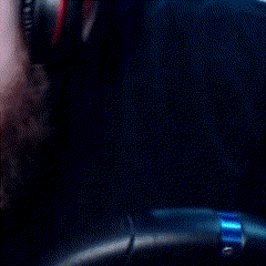 a man with a beard is wearing headphones and looking down